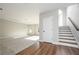 Living room features plush carpet, staircase with wood banister, and natural light at 6005 Crowley Dr, Douglasville, GA 30135