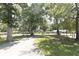 View of a long driveway leading up to a house with mature trees and a well-manicured lawn at 1112 Mealor Rd, Lawrenceville, GA 30043