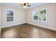 Spacious bedroom with hardwood floors, neutral paint, and ample natural light from the windows at 1560 Pontiac Se Pl, Atlanta, GA 30315