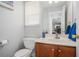 Cozy half bathroom featuring a wood cabinet, white counter and wallpaper at 201 Providence Dr, Dallas, GA 30157