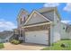A large two-car garage with stone accents and a driveway, located on a sunny lot at 201 Providence Dr, Dallas, GA 30157