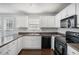 Bright kitchen featuring white cabinets, dark countertops, and stainless steel appliances at 201 Providence Dr, Dallas, GA 30157
