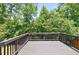 Back deck with a railing overlooking the trees at 5740 Zelkova Dr, Cumming, GA 30040