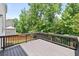 View of the spacious back deck with wooden railing and natural wooded surroundings at 5740 Zelkova Dr, Cumming, GA 30040