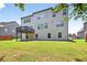 Back exterior view of the home showing the yard, walkout basement and upper-level deck at 5740 Zelkova Dr, Cumming, GA 30040