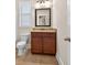 Cozy bathroom featuring a vanity with granite countertop, dark wood cabinets, and a framed mirror at 5740 Zelkova Dr, Cumming, GA 30040