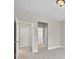Bedroom with neutral walls and carpet, showing doorways to a bathroom and closet at 5740 Zelkova Dr, Cumming, GA 30040