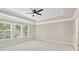 Bedroom with carpet, neutral walls, tray ceiling, ceiling fan and many windows at 5740 Zelkova Dr, Cumming, GA 30040