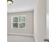 Bright bedroom featuring a large window with natural light, neutral paint, and plush carpeting at 5740 Zelkova Dr, Cumming, GA 30040