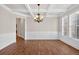 Elegant dining room featuring hardwood floors, chandelier, and coffered ceiling at 5740 Zelkova Dr, Cumming, GA 30040