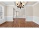 Elegant dining room with dark wood floors, a decorative chandelier, and classic white trim at 5740 Zelkova Dr, Cumming, GA 30040
