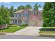 Charming brick home with manicured lawn, inviting porch, and a two-car garage at 5740 Zelkova Dr, Cumming, GA 30040