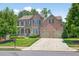 Lovely brick home featuring a two-car garage, lush lawn, and mature trees at 5740 Zelkova Dr, Cumming, GA 30040