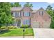 Beautiful brick home with a well-manicured lawn and attached two car garage at 5740 Zelkova Dr, Cumming, GA 30040