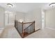 Upstairs hallway featuring wood railing and neutral colored walls and carpet at 5740 Zelkova Dr, Cumming, GA 30040