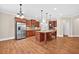 Open-concept kitchen with a center island, stainless steel appliances, and wood cabinets at 5740 Zelkova Dr, Cumming, GA 30040
