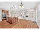Open-concept kitchen featuring an island, wooden cabinets, and stainless steel appliances, flowing into a spacious living area at 5740 Zelkova Dr, Cumming, GA 30040