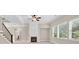 Bright living room with fireplace, a ceiling fan, and large windows offering ample natural light at 5740 Zelkova Dr, Cumming, GA 30040