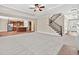 Open-concept living room showcasing a staircase, kitchen, and a view of the front entrance at 5740 Zelkova Dr, Cumming, GA 30040
