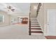 Spacious living room with wood stairs, showcasing an open floor plan leading to the kitchen at 5740 Zelkova Dr, Cumming, GA 30040