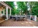 The covered back porch has a large table for outdoor dining surrounded by lush greenery at 1412 Lanier Ne Mnr, Atlanta, GA 30319