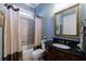 Bathroom with dark granite countertop, decorative mirror, tub/shower with curtain and neutral walls at 1412 Lanier Ne Mnr, Atlanta, GA 30319