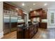 Kitchen featuring stainless steel refrigerator and appliances, dark wood cabinets, and a large island with a dark countertop at 1412 Lanier Ne Mnr, Atlanta, GA 30319