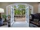Living room features french doors to outdoor living space, wing back chair, and neutral tones at 1412 Lanier Ne Mnr, Atlanta, GA 30319