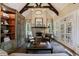 Living room showcases a stone fireplace, beamed ceilings, built-in shelving, and French doors at 1412 Lanier Ne Mnr, Atlanta, GA 30319