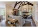 Open living area with hardwood floors, fireplace, exposed beams, and an elegant light fixture at 1412 Lanier Ne Mnr, Atlanta, GA 30319