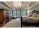 Cozy main bedroom featuring a tray ceiling, hardwood floors, and access to a private balcony at 1412 Lanier Ne Mnr, Atlanta, GA 30319