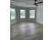 Bedroom featuring triple windows, modern ceiling fan and wood look flooring at 1522 Reserve Glen Dr, Lawrenceville, GA 30043