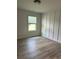 Bedroom featuring window, modern paneled wall and wood-look flooring at 1522 Reserve Glen Dr, Lawrenceville, GA 30043