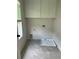 Compact laundry room with overhead cabinets and tile floor at 1522 Reserve Glen Dr, Lawrenceville, GA 30043