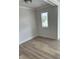 Empty room with modern ceiling light, window and wood-look flooring at 1522 Reserve Glen Dr, Lawrenceville, GA 30043