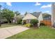 View of a single-story home with an inviting driveway, lush green grass, and mature trees at 1602 Buckingham Place Pl, Woodstock, GA 30188
