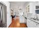 This open concept view showcases the refrigerator, cabinets, and living room with hardwood floors at 1602 Buckingham Place Pl, Woodstock, GA 30188