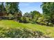 Spacious backyard with a fountain, trees and lush lawn on a sunny day; trampoline not visible from this angle at 7575 Hunters Woods W Dr, Atlanta, GA 30350