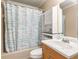 Cozy bathroom with tub/shower combination, white and blue curtain, and white cabinet with a small sink at 7575 Hunters Woods W Dr, Atlanta, GA 30350