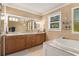 Bathroom with dual sink vanity, large mirror, decorative lighting, tile floors and backsplash, and bathtub at 7575 Hunters Woods W Dr, Atlanta, GA 30350