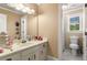 Functional bathroom with vanity sink, lots of countertop space, and natural light from window next to toilet and shower at 7575 Hunters Woods W Dr, Atlanta, GA 30350