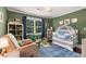 A lovely Bedroom featuring a crib, rocking chair, shelving for storage, and window for natural light at 7575 Hunters Woods W Dr, Atlanta, GA 30350