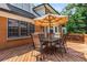 Wood deck with furniture including an umbrella and seating for six with a view of the home and surrounding trees at 7575 Hunters Woods W Dr, Atlanta, GA 30350