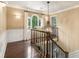 Hallway features a decorative chandelier, wooden banister, trimwork, and a window for an airy, elegant space at 7575 Hunters Woods W Dr, Atlanta, GA 30350