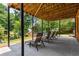 Covered outdoor patio with lounge chairs and a view of the lush, green backyard at 7575 Hunters Woods W Dr, Atlanta, GA 30350