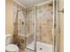 Elegant shower with glass doors, tiled walls, built-in seat, and modern fixtures at 7575 Hunters Woods W Dr, Atlanta, GA 30350