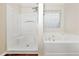Bathroom featuring a tub and shower, paired with a window that brings in natural light at 1338 Gates Se Dr, Atlanta, GA 30316