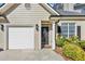 Close-up of the exterior, shows a single-car garage, front door with oval window, and well-kept landscaping at 1338 Gates Se Dr, Atlanta, GA 30316