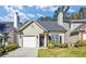 Charming home featuring a well-maintained lawn and appealing front facade with an attached garage and black door at 1338 Gates Se Dr, Atlanta, GA 30316