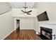 Bright living room with wood floors, fireplace, TV, ceiling fan, and adjacent staircase to the upper level at 1338 Gates Se Dr, Atlanta, GA 30316